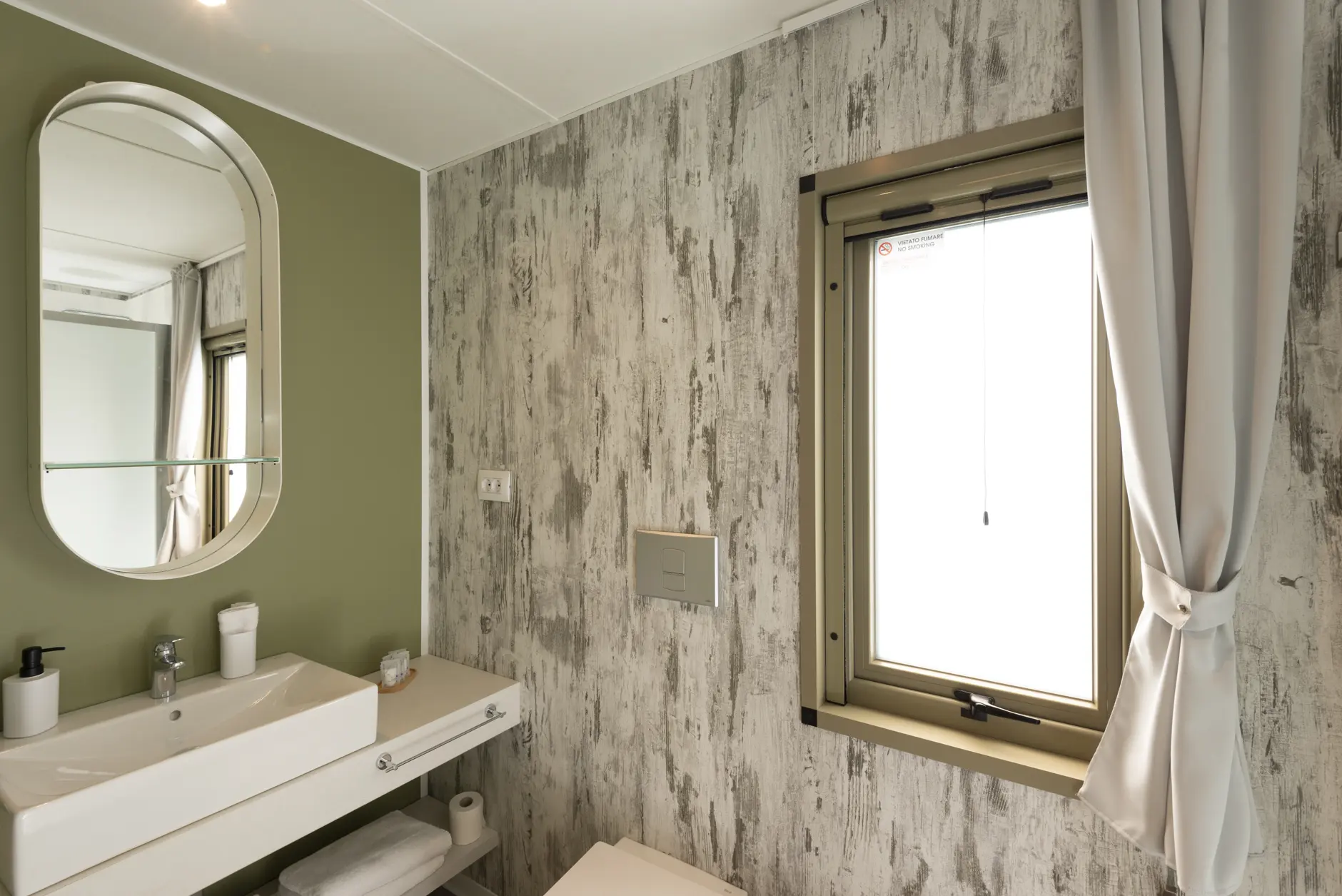 Bagno privato di un Lodge di Amaranto con lavabo, specchio e finestra