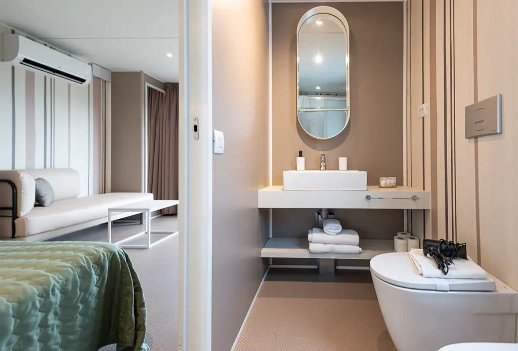 Bagno privato di un Lodge di Amaranto con lavabo, WC e zona giorno sullo sfondo