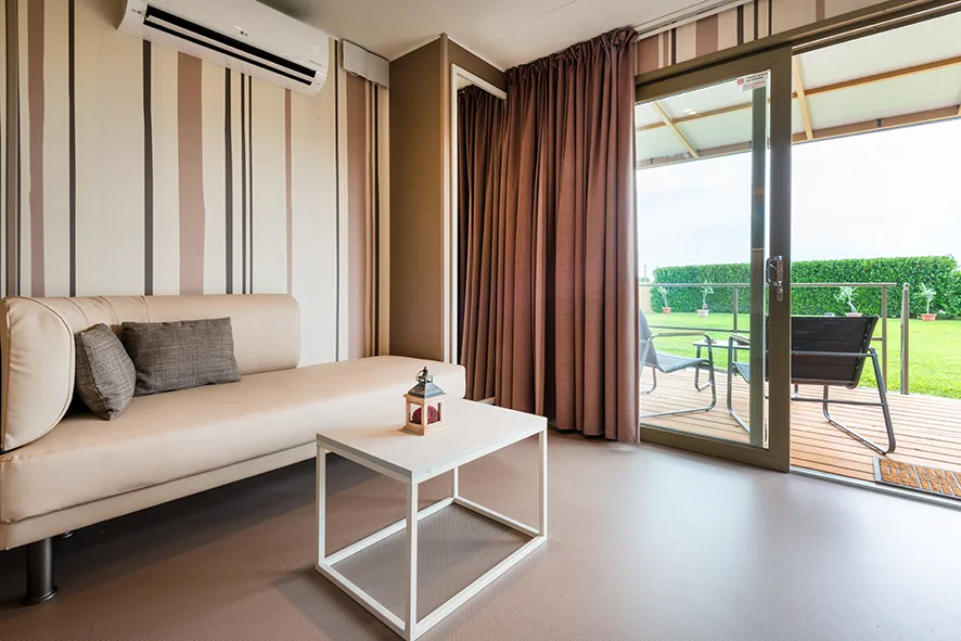 Zona giorno di un Lodge di Amaranto con divano e accesso alla veranda privata